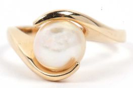 A modern pearl single stone ring set between crossover angular shoulders, stamped 14k, size M