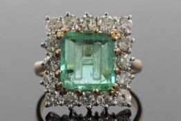 An emerald and diamond ring, the emerald engraved with the letter 'H', 10.19 x 9.62 x 3.15mm,