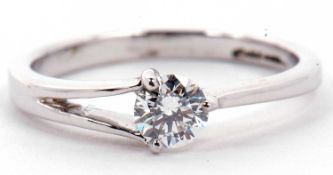 A solitaire diamond ring, a three claw set design with one single split shoulder, the round