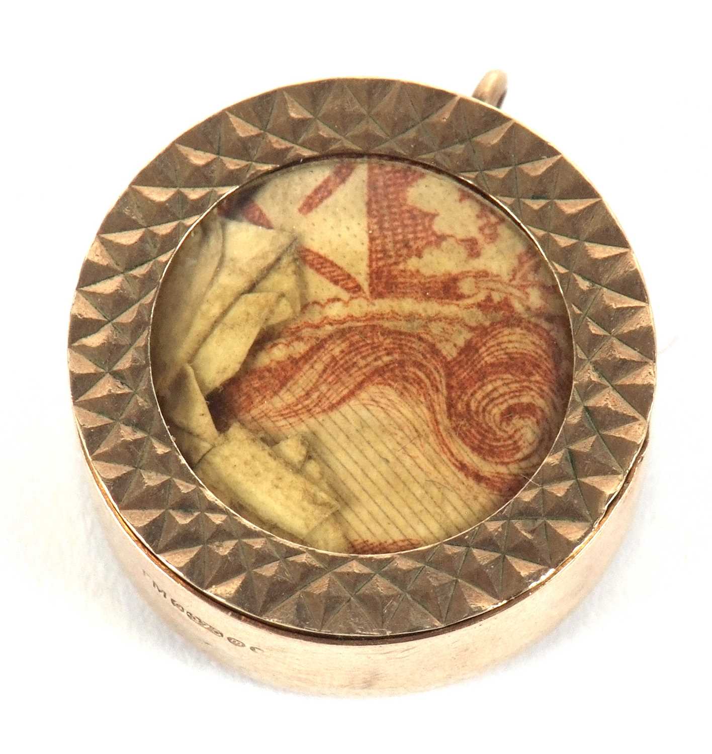 A 9ct gold charm, the circular disc with glazed panel and containing a 10 shilling note,