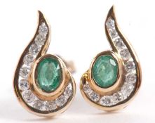 A pair of 9ct emerald and diamond earrings, the central collet mounted oval emerald, half surrounded