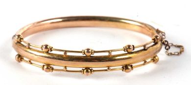 A late Victorian Etruscan style hinged bangle, the upper half with plain centre section and set to