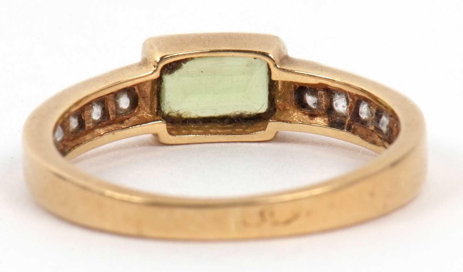 A peridot and diamond ring centering a rectangular cut peridot in rub over setting raised between - Image 3 of 6