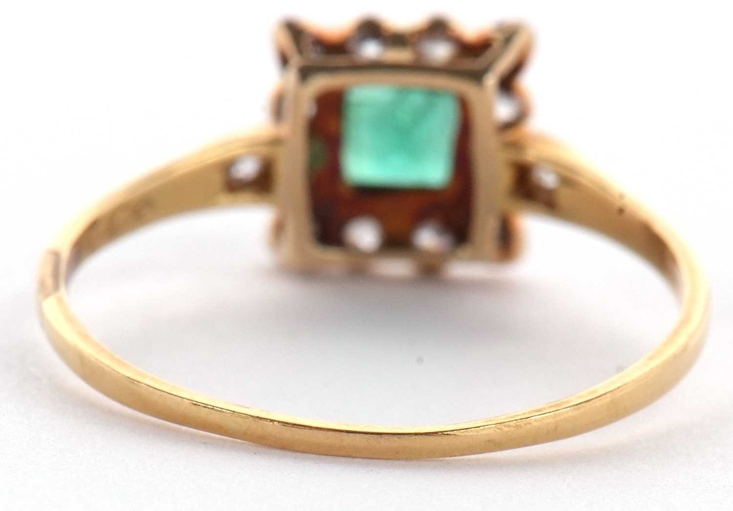 An emerald and diamond ring, the square step cut emerald, collet mounted with a surround of single - Image 5 of 11