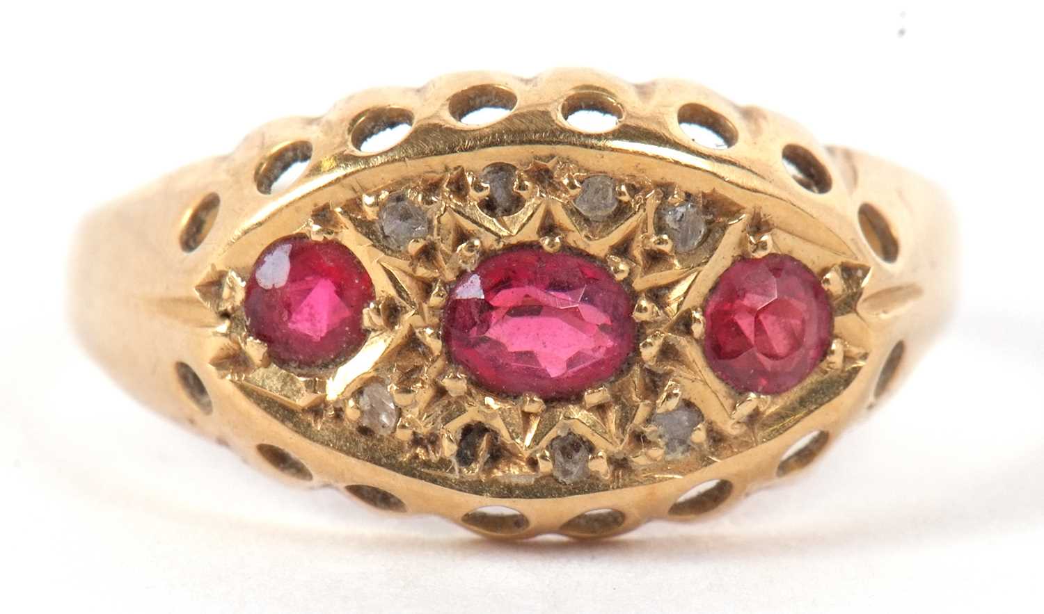 An 18ct ruby and diamond ring, the oval and round rubies set within a marquise shaped plaque set