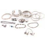 A quantity of silver and white metal jewellery to include four bangles, an amber cabochon