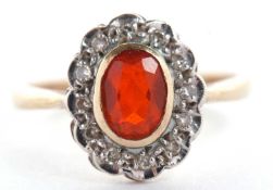A 9ct fire opal and diamond ring, the oval fire opal in rubover mount, surrounded by small round