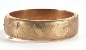 A 9ct hinged bangle, the upper half with textured and engraved swans, the lower half plain,