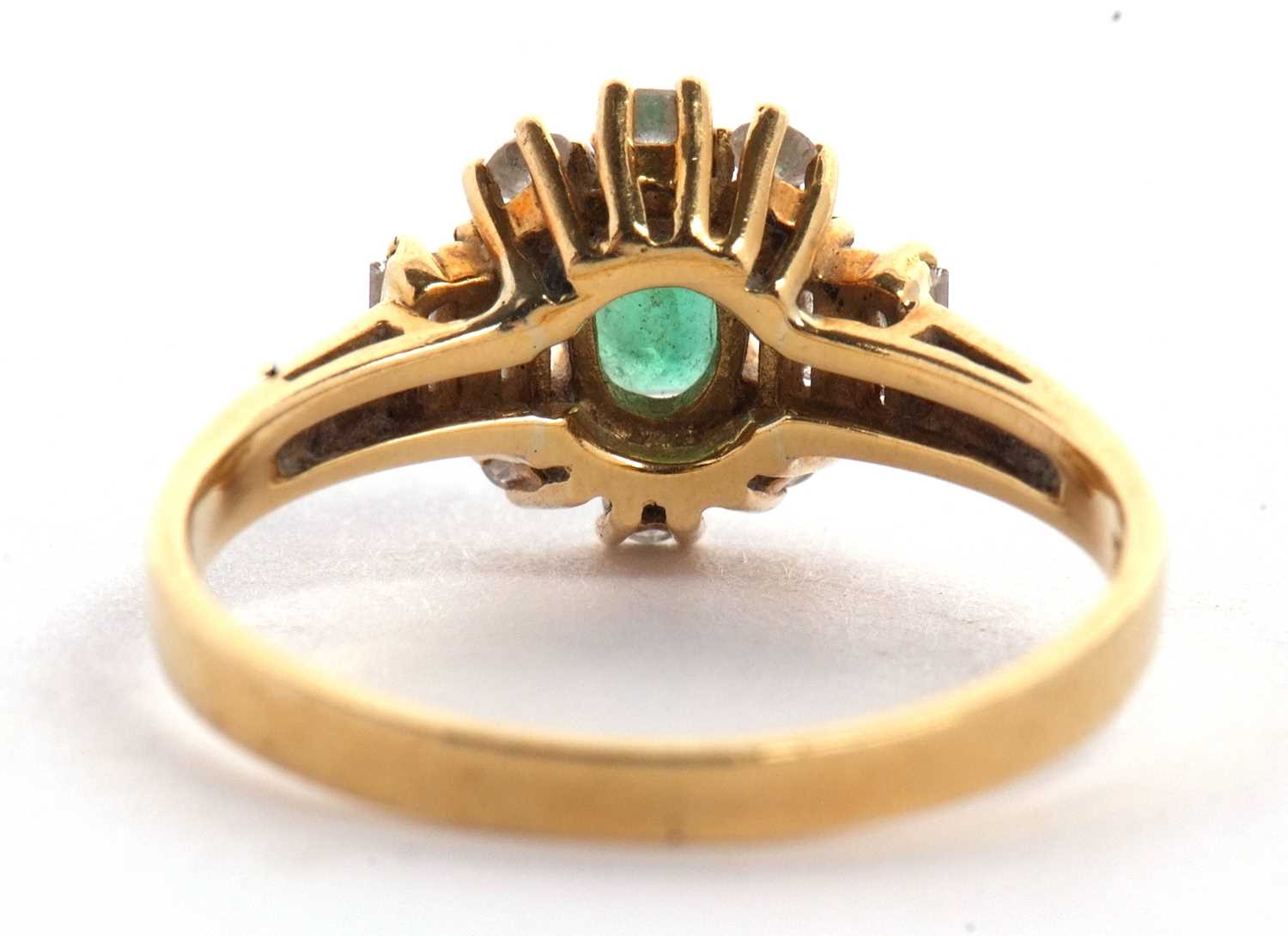 An 18ct emerald and diamond ring, the central oval emerald set with three small round diamonds above - Image 4 of 16