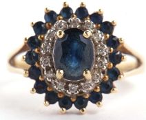 An 18ct sapphire and diamond cluster ring, the central oval sapphire surrounded by small round