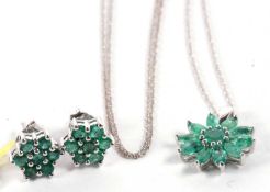 A 9ct white gold and emerald necklace and matching earrings, the emerald flowerhead pendant, with