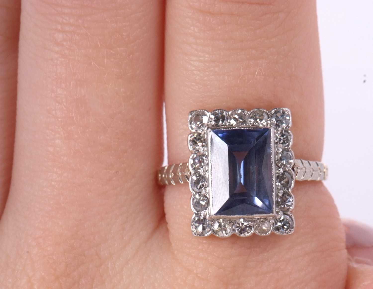 A sapphire and diamond ring, the radiant cut sapphire, approx. 9.9 x 6.9 x 4.9mm, surrounded by - Image 8 of 8