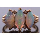 An 18ct three stone opal ring, the three marquise opal cabochons, set with diamond highlights above,