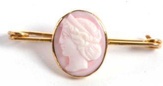 A cameo bar brooch, the oval pale pink shell cameo, in rubover mount, approx. 18mm high, fitted with
