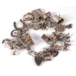 A charm bracelet with heart shaped padlock clasp stamped 'silver' and a quantity of variously marked