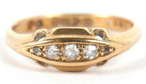 An early 20th century 18ct diamond ring, the three graduated single cut diamonds set to either end