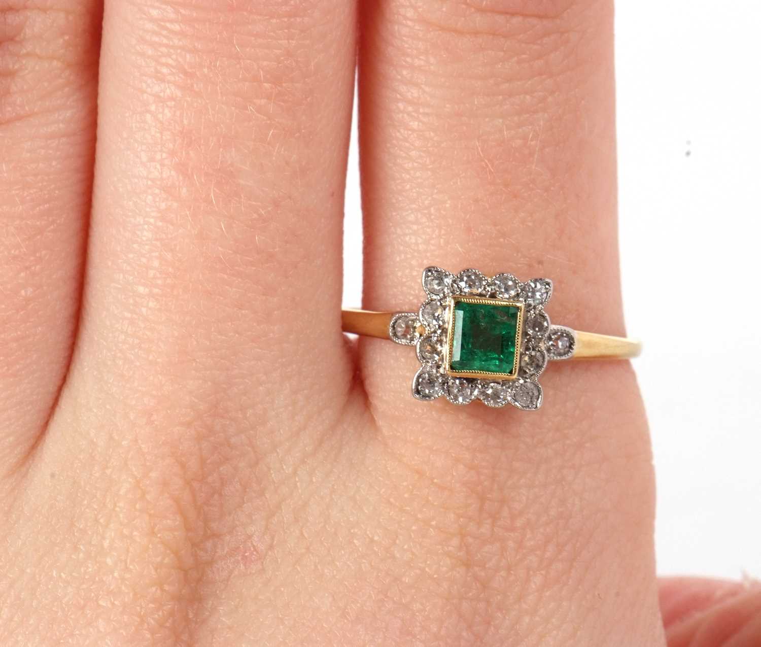 An emerald and diamond ring, the square step cut emerald, collet mounted with a surround of single - Image 9 of 11