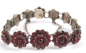 A faux garnet bracelet, comprised of graduated clusters with closed backs in unmarked white metal,
