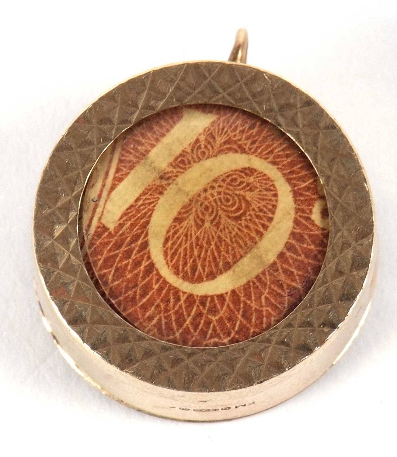 A 9ct gold charm, the circular disc with glazed panel and containing a 10 shilling note, - Image 2 of 3