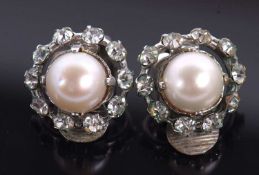 A pair of Christian Dior earclips, the central cultured pearl surrounded by white paste, set with