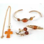 A 9ct amber bangle (a/f), 10g, together with an amber cross with bale stamped 585 and chain with