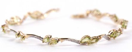 A 9ct peridot bracelet, comprised of two off-set marquise peridots, set between with bi-colour