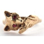 A 9ct fox ring, the fox head set with red hardstone eyes, curling round with tail meeting at other