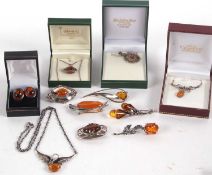 A quantity of amber jewellery to include an amber rosebud brooch, a double sided amber fob necklace,