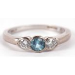 An 18ct white gold diamond and aquamarine ring, the central round aquamarine set to either side with