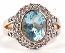 A 9ct topaz and diamond ring, the oval pale blue topaz, in rubover mount, surrounded by pave set