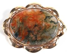 A 9ct mounted moss agate specimen brooch, collet mounted with pierced decorative surround,