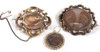 Two late Victorian hairwork memorial brooches and a pendant, to include an oval hairwork and seed