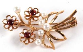 A 9ct cultured pearl and gemset floral spray brooch, the three flowerheads set with deep pinky-