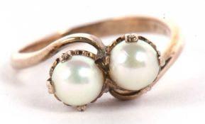 A two stone cultured pearl crossover ring, both pearls claw mounted to a plain band stamped 9ct,