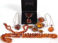 A quantity of amber jewellery to include two amber bead necklaces, (48g), together with a large oval