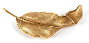 An 18ct leaf brooch, the naturalistically modelled leaf with textured and satin finish, stamped