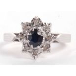 An 18ct sapphire and diamond ring, the central oval sapphire surrounded by eight small illusion