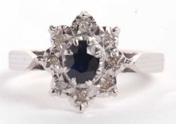 An 18ct sapphire and diamond ring, the central oval sapphire surrounded by eight small illusion