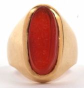 High grade yellow metal and carnelian set ring, the elongated oval shaped carnelian carved with