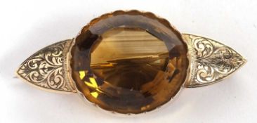 A 9ct citrine brooch, the large oval citrine, approx. 24 x 20 x 13mm, in a deep collet mount with