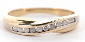 A 9ct diamond crossover ring, the round brilliant cut diamonds, channel set in a crossover style