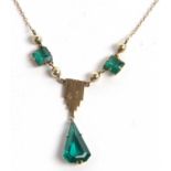 A green paste necklace, the central green dropped suspended from a fringe of yellow metal, on a