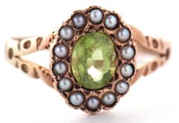 A 9ct peridot and seed pearl ring, the oval peridot surrounded by seed pearls, with split