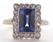 A sapphire and diamond ring, the radiant cut sapphire, approx. 9.9 x 6.9 x 4.9mm, surrounded by