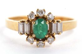 An 18ct emerald and diamond ring, the central oval emerald set with three small round diamonds above