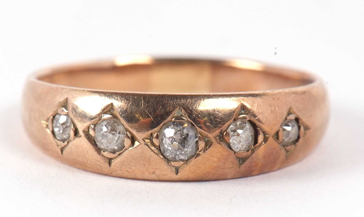 A five stone diamond ring, the five old mine cut diamonds, gypsy set to a plain band of unmarked