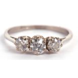 An 18ct white gold three stone diamond ring, the three round brillinat cut diamonds, total estimated