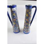 Two large delft style ewers with polychrome design of flowers