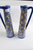 Two large delft style ewers with polychrome design of flowers