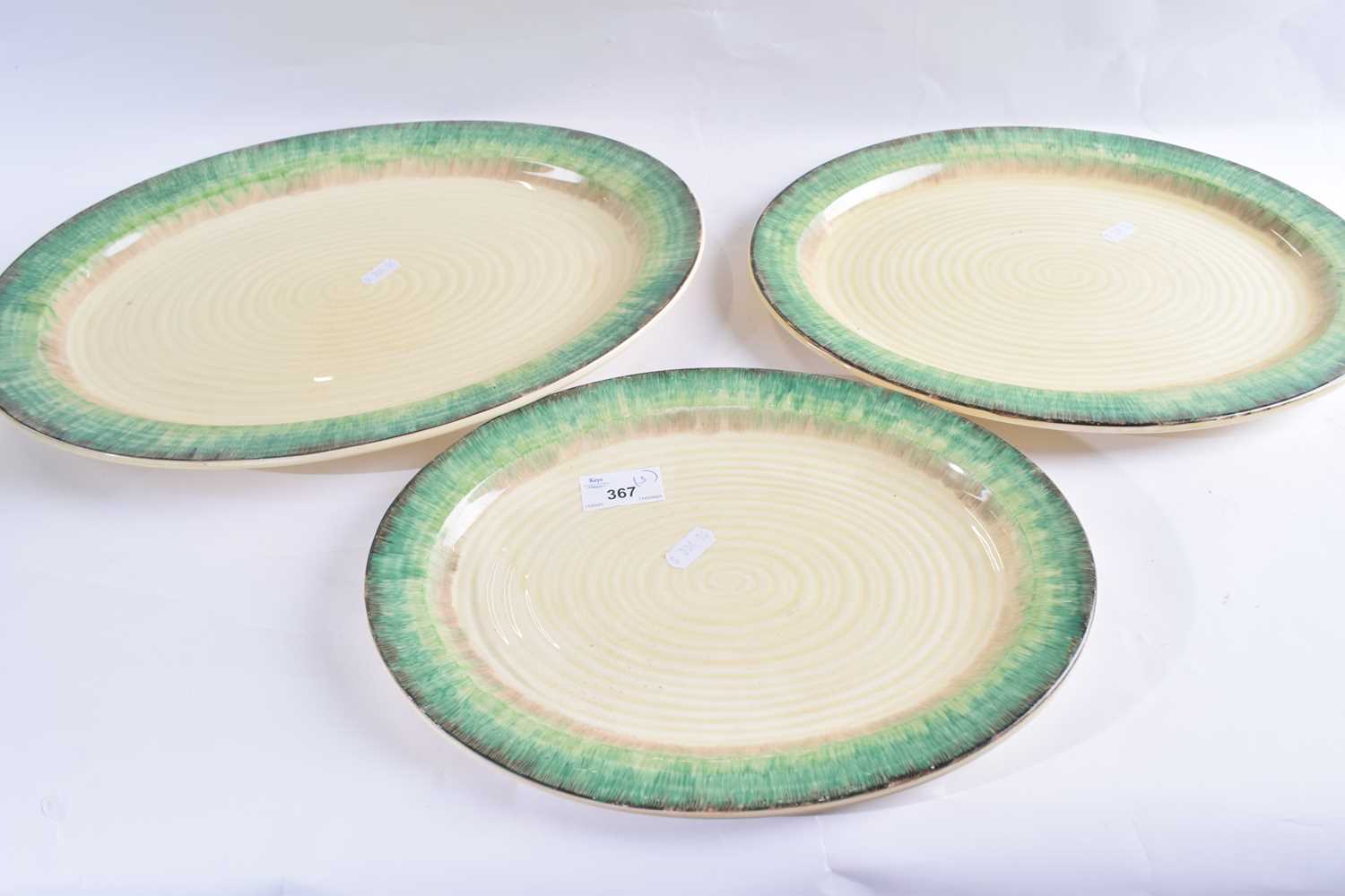 A graduated set of three Clarice Cliff bizarre serving dishes of ribbed form with green mottled